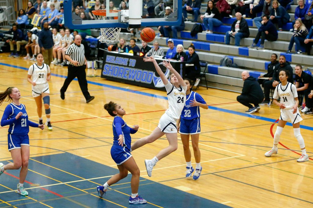 Everett sophomore Tatum Smith scores an acrobatic shot after being fouled against Seattle Prep during a playoff matchup at Shorewood High School on Saturday, Feb. 24, 2024, in Shoreline, Washington. (Ryan Berry / The Herald)