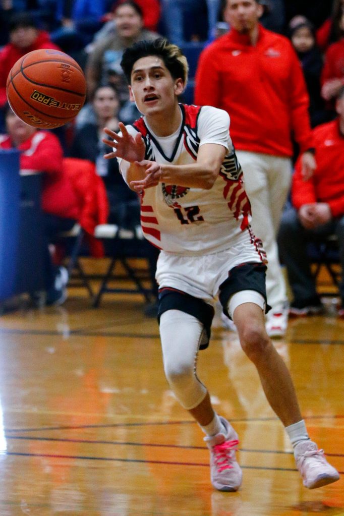 Tulalip Heritage senior Adrian Jefferson passes down low to a teammate against Columbia Adventist Academy during a playoff matchup at Arlington High School on Saturday, Feb. 24, 2024, in Arlington, Washington. (Ryan Berry / The Herald)