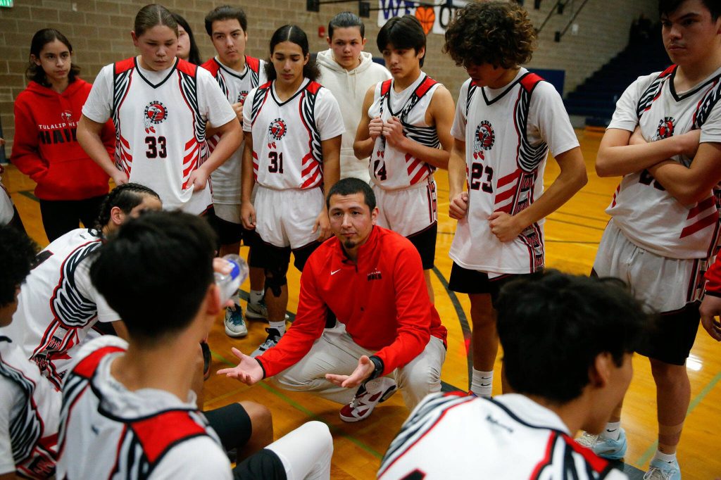 Tulalip Heritage head coach Shawn Sanchey speaks with his team between quarters of a playoff matchup against Columbia Adventist Academy at Arlington High School on Saturday, Feb. 24, 2024, in Arlington, Washington. (Ryan Berry / The Herald)