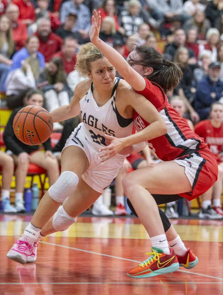 Arlingtons Samara Morrow tries to maneuver around Snohomishs Sienna Capelli during the 3A girls district championship game Feb. 17 in Marysville. (Olivia Vanni / The Herald)