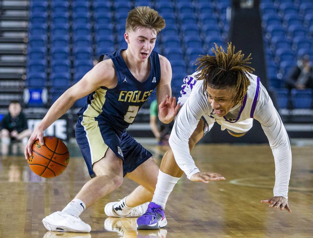 Arlingtons Leyton Martin fakes out Garfields Marcel Jones during the 3A boys state basketball game on Wednesday, Feb. 28, 2024 in Tacoma, Washington. (Olivia Vanni / The Herald)
