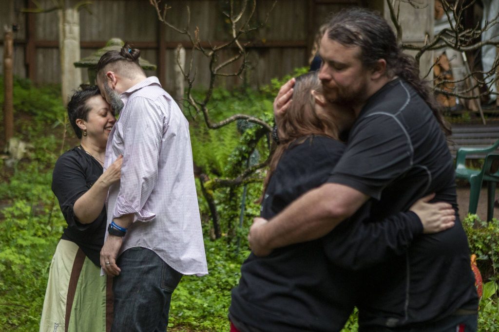 Left to right, Tasha Zebrowan, Pip Zebrowan, Lilliana Blackstar and Josh Carpenter embrace their partners after the maypole ritual during Beltane in May 2023, at the Aquarian Tabernacle Church in Index, Washington. Beltane celebrates the height of spring. (Annie Barker / The Herald)