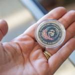 Coins commemorating the first flight from Paine Field to Honolulu are handed out to passengers on Nov. 17, 2023 in Everett, Washington. (Olivia Vanni / The Herald)
