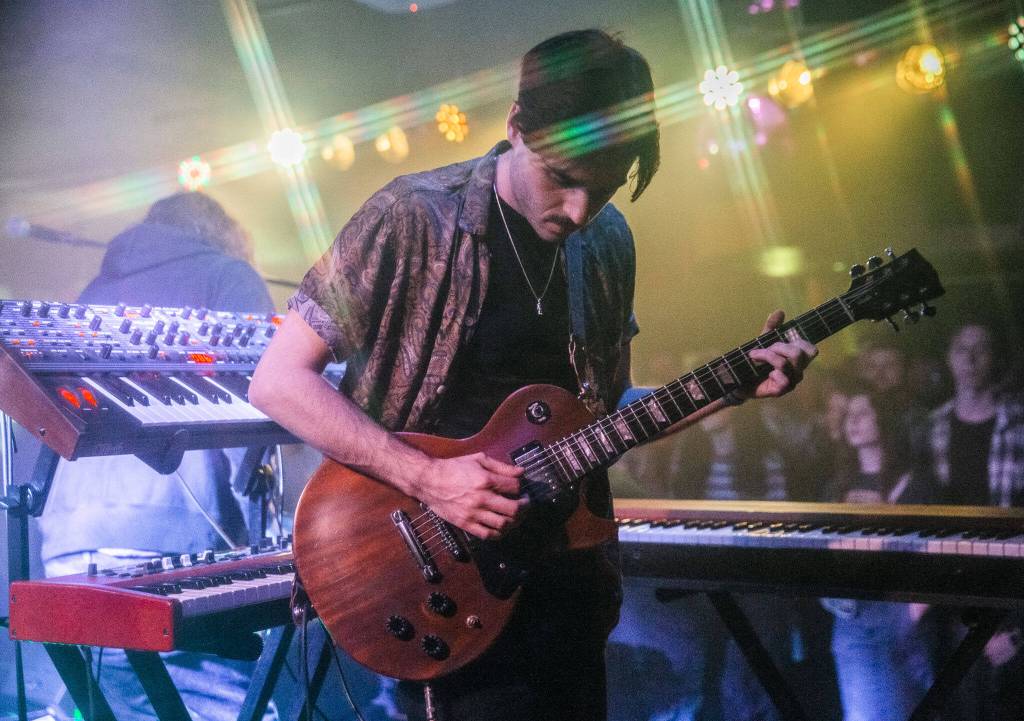 Owen Mayo of Cytrus picks up his guitar to play during a headlining show at Madame Lous on Friday, Dec. 29, 2023 in Seattle, Washington. (Olivia Vanni / The Herald)