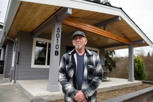 Glen Olin, 83, in front of the last home he will ever build on Wednesday, March 20, 2024 in Everett, Washington. Olin retired “sort of” after more than 60 years of building homes. (Olivia Vanni / The Herald)