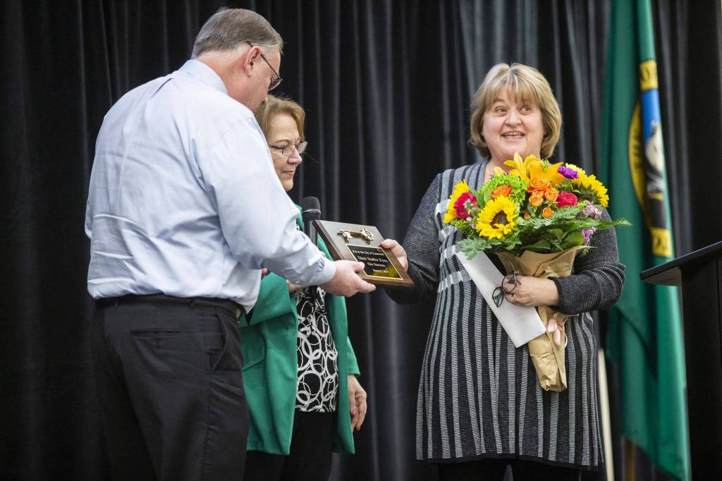 Lynnwood historian Cheri Ryan, right, receives a key to the city of Lynnwood on Wednesday, March 6, 2024 in Lynnwood, Washington. (Olivia Vanni / The Herald)