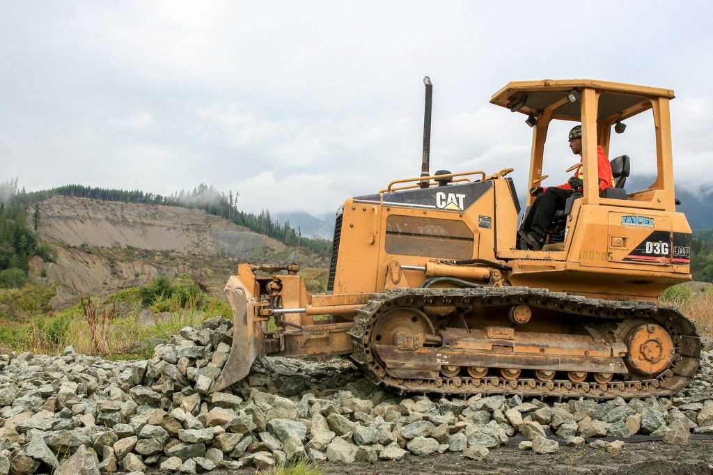 Jacques Hennequin operates the bull dozer in rebuilding the mile of the Whitehorse Trail destroyed by the Oso mudslide. (Kevin Clark / The Daily Herald)
