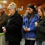 Tawnya Nettles, Gabby Kernaghan, and other community members (from right to left) pray during a candlelight vigil at the Darrington Community Center, Saturday, April 5, 2014, in Darrington, Wash. (Sofia Jaramillo / The Herald)