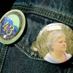 Tim Ward, who lost his wife Brandy in a 2014 landslide in Oso, Wash., wears buttons with Brandys photo and another commemorating all of the 43 deaths from the slide as he attends a session of King County Superior Court, Monday, Oct. 10, 2016, in Seattle. It was announced Monday that a settlement had been reached in a lawsuit brought by survivors and family members of people killed in the slide against the state of Washington and a timber company that logged an area above the site of the slide. (AP Photo/Ted S. Warren)