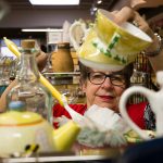 Volunteer Judi Drake dusts under and around teapots at the Assistance League of Everett on Monday, Nov. 18, 2019 in Everett, Wash. They sell items at their thrift store and donate all the proceeds to families in Snohomish County. All of the 300 people who help out are volunteers. (Andy Bronson / The Herald)
