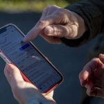 Rachel Haight from the Whale Sighting Network tells a passerby how to report sightings of gray and orca whales on Monday, March 18, 2024 at Sandy Point in Langley, Washington. (Annie Barker / The Herald)