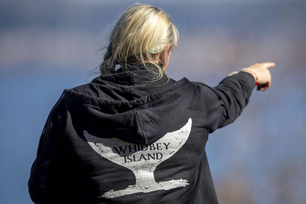 Cindi Rausch looks for whales on Monday, March 18, 2024 on Whidbey Island in Washington. (Annie Barker / The Herald)