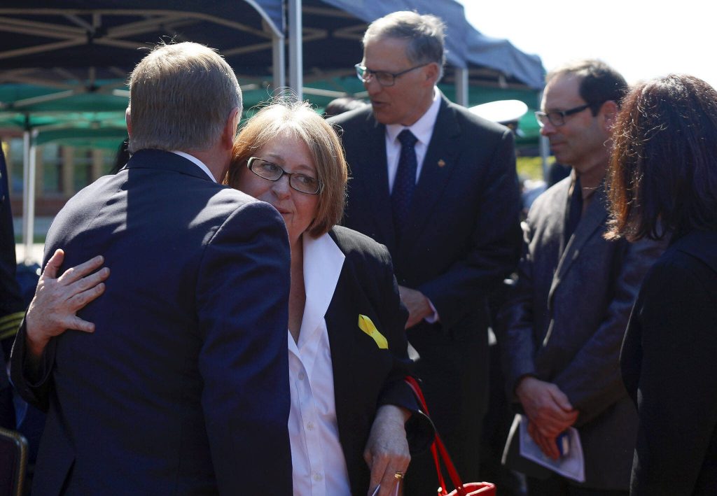 Arlington Mayor Barb Tolbert hugs Everett Mayor Ray Stephanson after the ceremony.  Gov. Jay Inslee, Rep. Susan Del Bene and Darrington Mayor Dan Rankin were also in attendance on April, 25, 2014. (Genna Martin / The Herald)