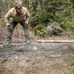 Ellyn Ritchotte looks over the sharp ledge of the washed out road on Wednesday, March 6, 2024 in Marysville, Washington. (Olivia Vanni / The Herald)