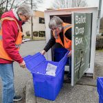 Snohomish County election staff Carolyn Thostenson, left, and Chris Faith, right, collect ballots from a drop box next to the Mill Creek Post Office on Friday, March 8, 2024 in Mill Creek, Washington. (Olivia Vanni / The Herald)