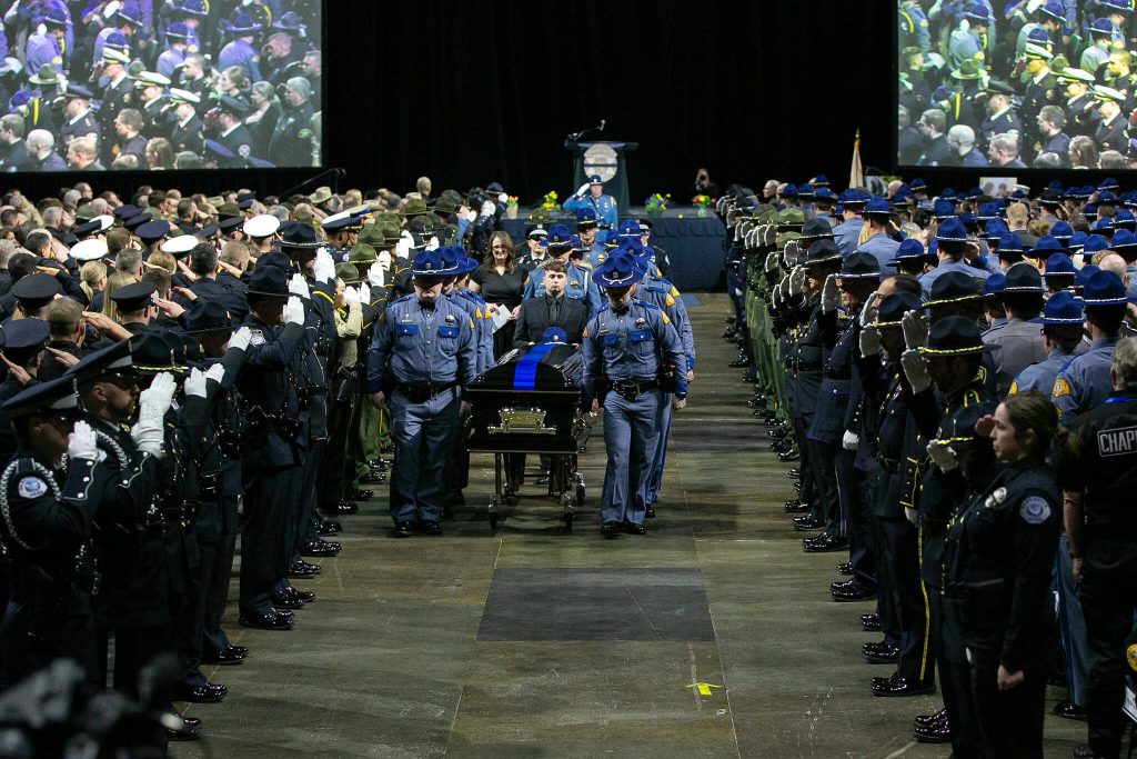 Washington State Patrol trooper Chris Gadds casket is brought out by fellow troopers following a memorial ceremony on Tuesday, March 12, 2024, at Angel of the Winds Arena in Everett, Washington. (Ryan Berry / The Herald)