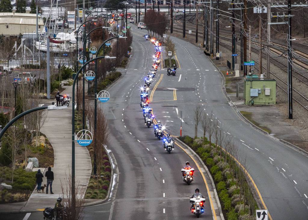 Washington State Patrol troopers on motorcycles ride down Marine View Drive in a memorial procession for fallen trooper Chris Gadd on Tuesday, March 12, 2024 in Everett, Washington. (Olivia Vanni / The Herald)
