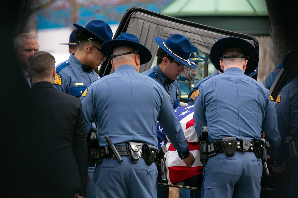 Fellow troopers carry the casket of Washington State Patrol trooper Chris Gadd on Tuesday, March 12, 2024, during a memorial at Angel of the Winds Arena in Everett, Washington. (Ryan Berry / The Herald)