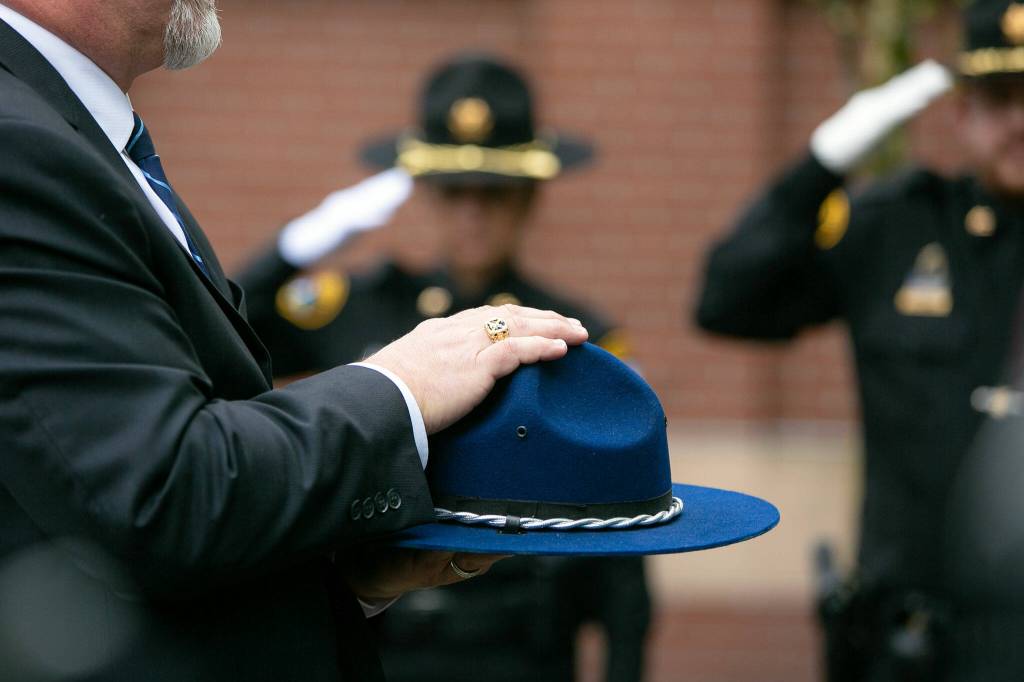 A troopers hat is carried behind Washington State Patrol trooper Chris Gadds remains during a memorial on Tuesday, March 12, 2024, at Angel of the Winds Arena in Everett, Washington. (Ryan Berry / The Herald)
