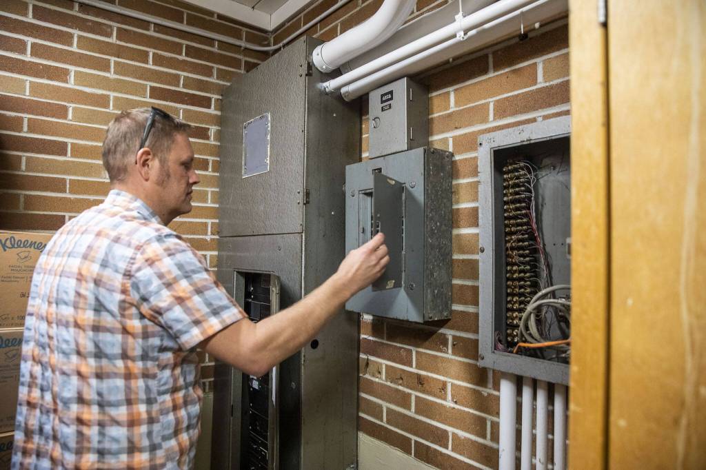 Lakewood District Facilities Director Alex VanDuine opens one of the dated electric boxes at Lakewood Elementary School on Tuesday, March 19, 2024, in Marysville, Washington. (Olivia Vanni / The Herald)