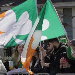 Spectators display flags while watching the annual St. Patricks Day parade, March 19, 2023, in Bostons South Boston neighborhood. (Steven Senne / Associated Press)