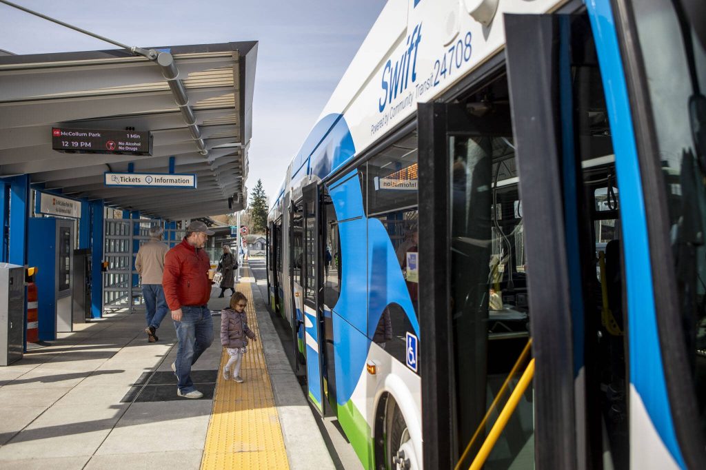 People board a bus during the Swift Orange Line celebration at the Lynnwood Transit Center on Saturday, March 30, 2024, in Lynnwood, Washington. (Annie Barker / The Herald)