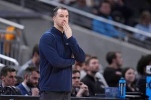 Utah State head coach Danny Sprinkle is seen on the sidelines during the first half of a second-round college basketball game against Purdue in the NCAA Tournament, Sunday, March 24, 2024 in Indianapolis. (AP Photo/Michael Conroy)