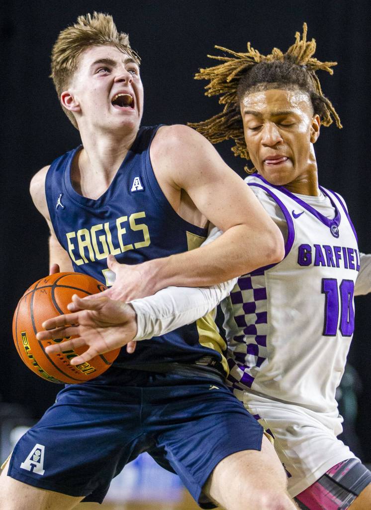 Arlingtons Leyton Martin attempts a layup while being guarded during the Class 3A boys state tournament game Feb. 28 in Tacoma. (Olivia Vanni / The Herald)