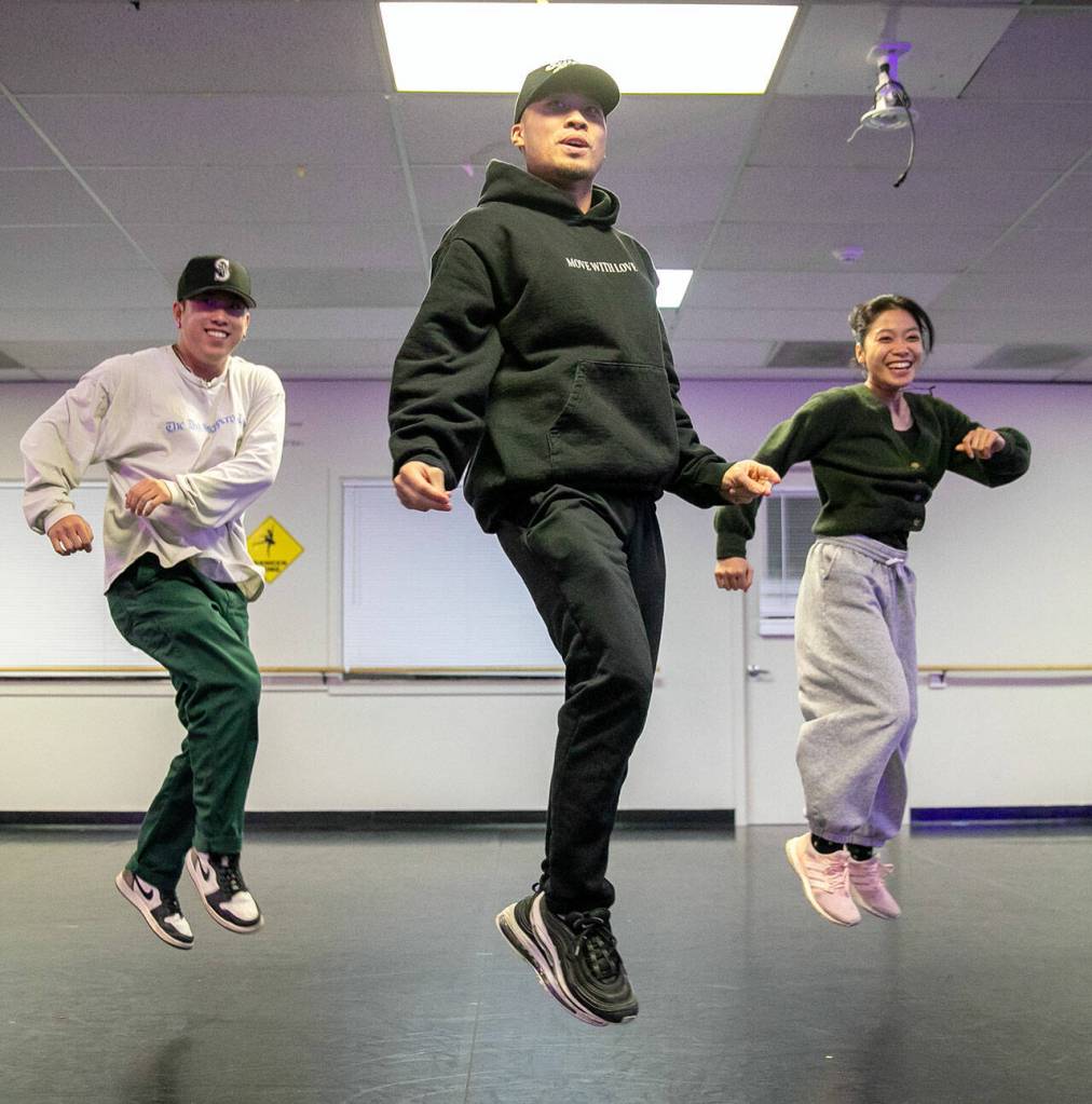 From left, Jon Kim, Pon Nuth and Lauren Mangibin take to the air while working on a new sequence during a RTHMZ rehearsal in Lynnwood. (Ryan Berry / The Herald)