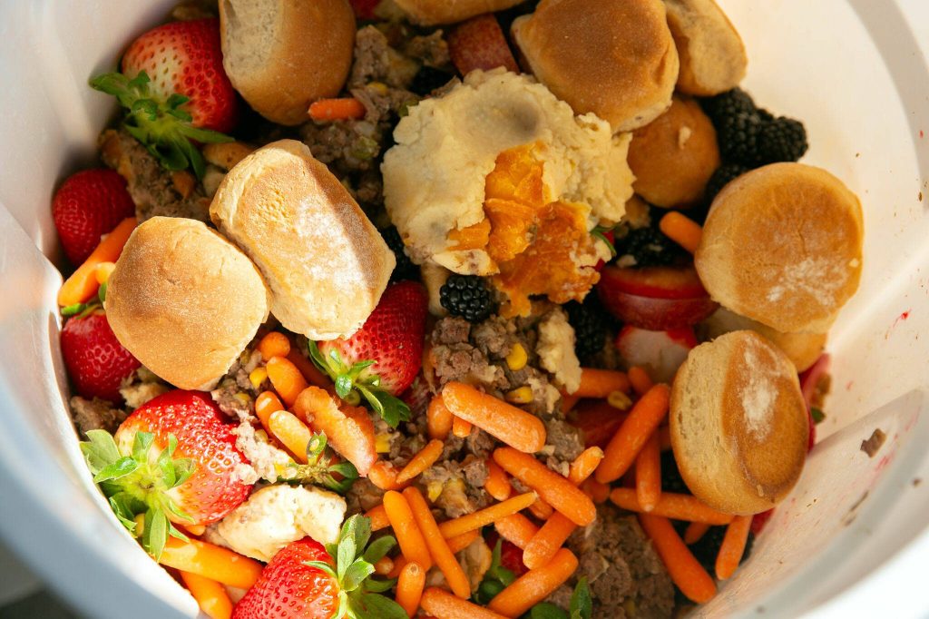 Leftovers from a shepherds pie lunch are stored in a bucket behind the Darrington School District cafeteria on Friday, March 15, 2024, in Darrington, Washington. (Ryan Berry / The Herald)