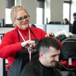 Bethany Teed, a certified peer counselor with Sunrise Services and experienced hairstylist, cuts the hair of Eli LeFevre during a resource fair at the Carnegie Resource Center on Wednesday, March 6, 2024, in downtown Everett, Washington. (Ryan Berry / The Herald)