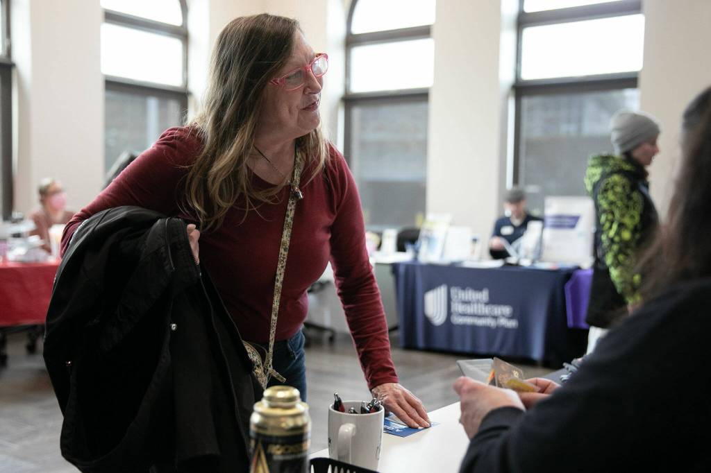 Marcella Wannquist collects a QFC gift card she won during a resource fair at the Carnegie Resource Center on Wednesday, March 6, 2024, in downtown Everett, Washington. (Ryan Berry / The Herald)