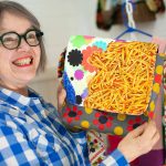 Artist Frances Peterson cracks a smile while showing off a bag of her design at Milkwood on Sunday, March 31, 2024, in Index, Washington. (Ryan Berry / The Herald)