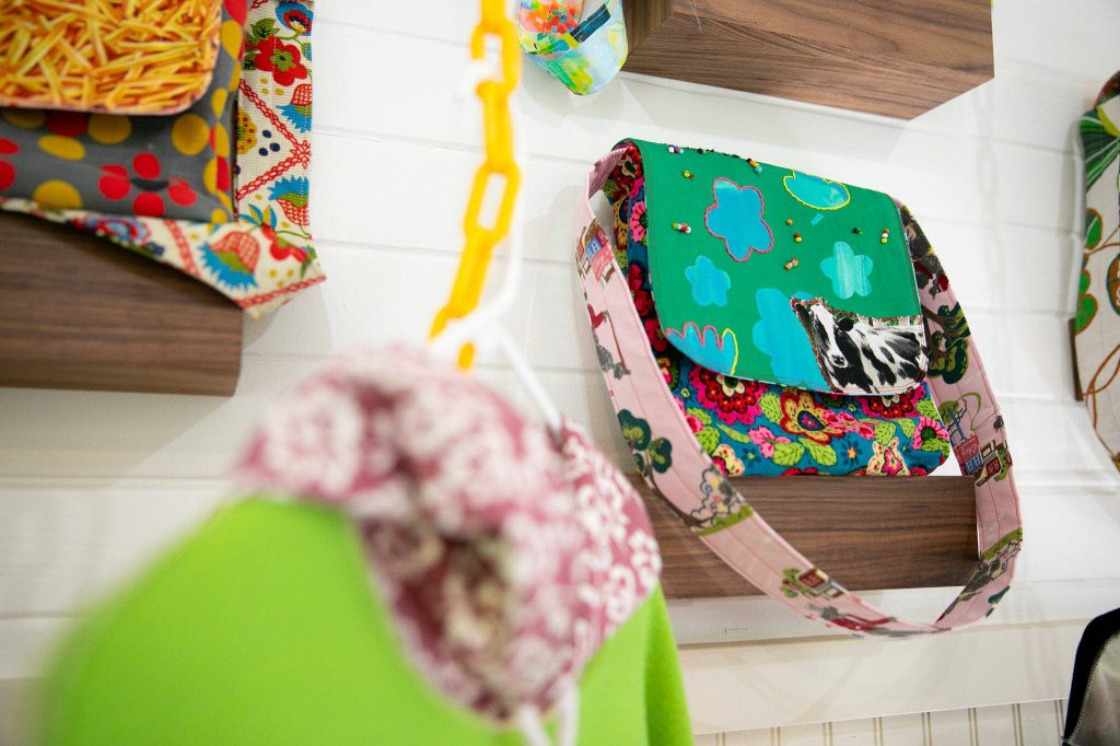 Multiple bags, including one titled How Mooo-ving are displayed on a wall at Milkwood on Sunday, March 31, 2024, in Index, Washington. (Ryan Berry / The Herald)