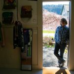 Frances Peterson leans in the doorway of Milkwood on Sunday, March 31, 2024, in Index, Washington. (Ryan Berry / The Herald)