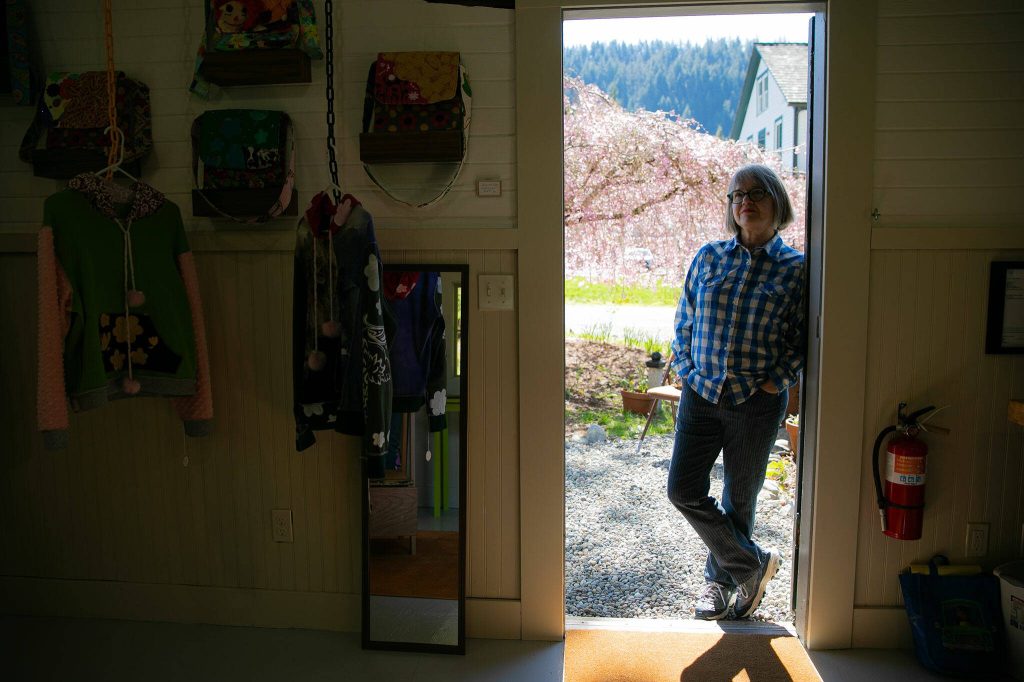 Frances Peterson leans in the doorway of Milkwood on Sunday, March 31, 2024, in Index, Washington. (Ryan Berry / The Herald)