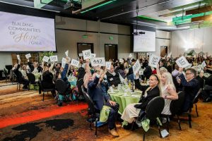 Attendees raise their hands to donate at the Compass Health fundraiser at the Tulalip Resort Casino on Saturday, March 25, 2023. (Courtesy photo)