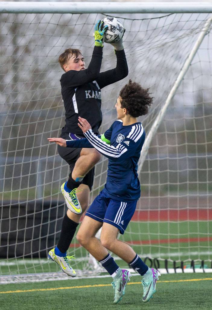 Kamiaks Otto Richter leaps in the air to catch the ball before Glacier Peaks Nicholas Miller can get his head on it during the game on Monday, April 1, 2024 in Snohomish, Washington. (Olivia Vanni / The Herald)