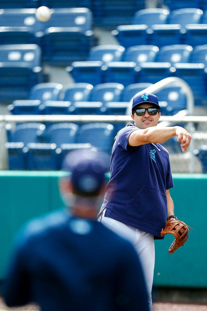 Everett AquaSox manager Ryan Scott plays catch behind the batting cage during practice Tuesday, April 2, 2024, at Funko Field in Everett, Washington. (Ryan Berry / The Herald)