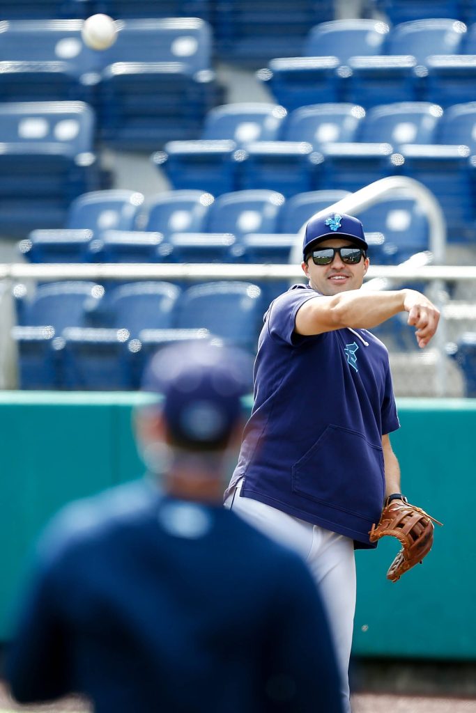 Everett AquaSox manager Ryan Scott plays catch behind the batting cage.