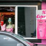 Emma Dilemma, a makeup artist and bikini barista, serves a drink to a customer while dressed as Lily Munster on Oct. 25, 2022, at XO Espresso on 41st Street in Everett, Washington. (Ryan Berry / The Herald)