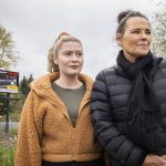 Carol McKinnon, right, the mother of Taylor Druliner, and Druliners best friend Brecca Blas, left, stand in front of a billboard searching for the suspect in the fatal hit and run of Taylor Druliner on Tuesday, April 9, 2024 in Everett, Washington. (Olivia Vanni / The Herald)