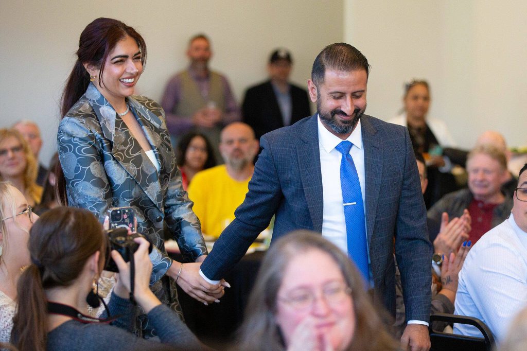 Dr. Baljinder S. Gill and Lavleen Samra-Gill head up to the front of the room after being named winners of the inaugural Emerging BNusiness Award during the 2024 Snohomish County Emerging Leaders Awards Presentation on Wednesday, April 17, 2024, in Everett, Washington. (Ryan Berry / The Herald)