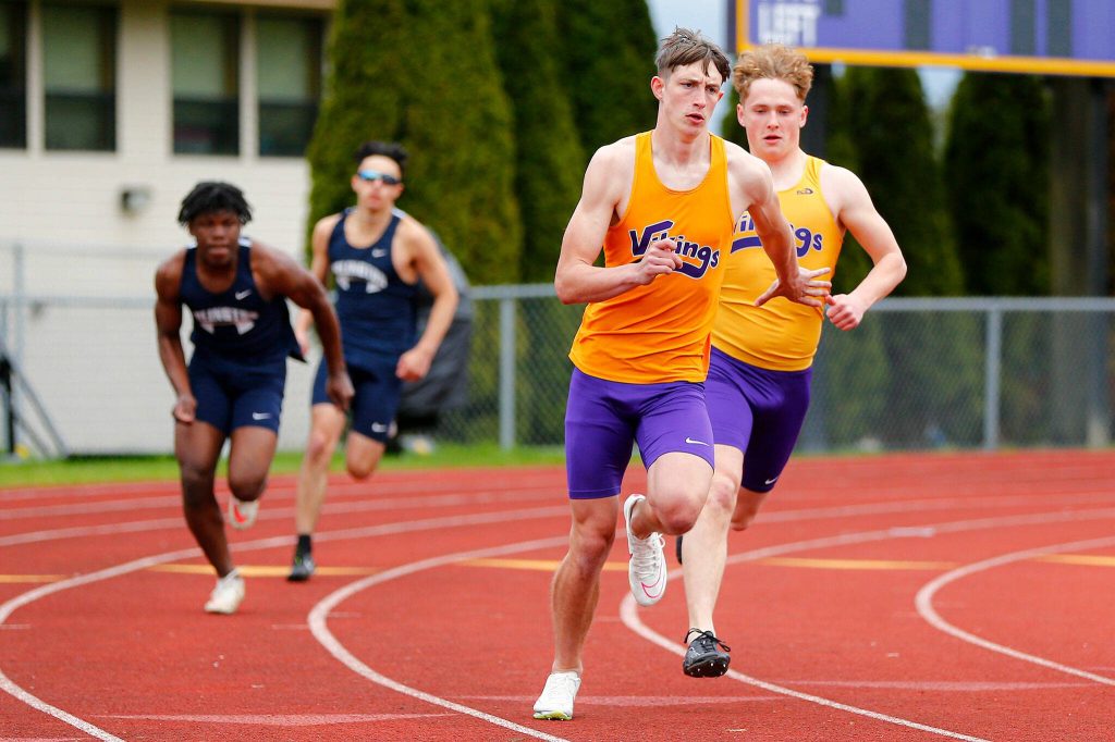 Lake Stevens David Brown takes a handoff from Jesse Lewis before sealing a win in the 4x100 relay during a meet Thursday, April 11, 2024, in Lake Stevens, Washington. (Ryan Berry / The Herald)