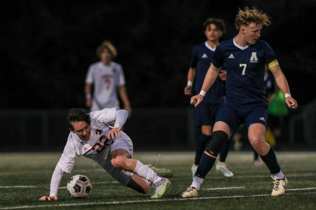 Archbishop Murphys Paul Holeman (22) trips fighting for the ball during a boys soccer game between Archbishop Murphy and Arlington at Arlington High School on Monday, April 15, 2024 in Arlington, Washington. (Annie Barker / The Herald)