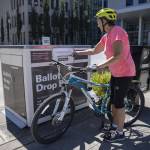 Dorothy Crossman rides up on her bike to turn in her ballot  on Tuesday, Aug. 1, 2023 in Everett, Washington. (Olivia Vanni / The Herald)