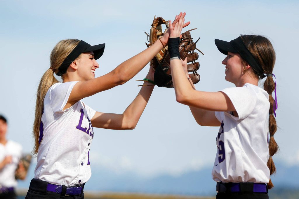 Lake Stevens pitcher Charli Pugmire high fives first baseman Emery Fletcher after getting out of an inning against Glacier Peak on Tuesday, April 23, 2024, at Glacier Peak High School in Snohomish, Washington. (Ryan Berry / The Herald)