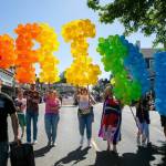 People begin parading down First Street with a giant balloon “PRIDE” during Snohomish’s inaugural Pride celebration on Saturday, June 3, 2023, in downtown Snohomish, Washington. (Ryan Berry / The Herald)
