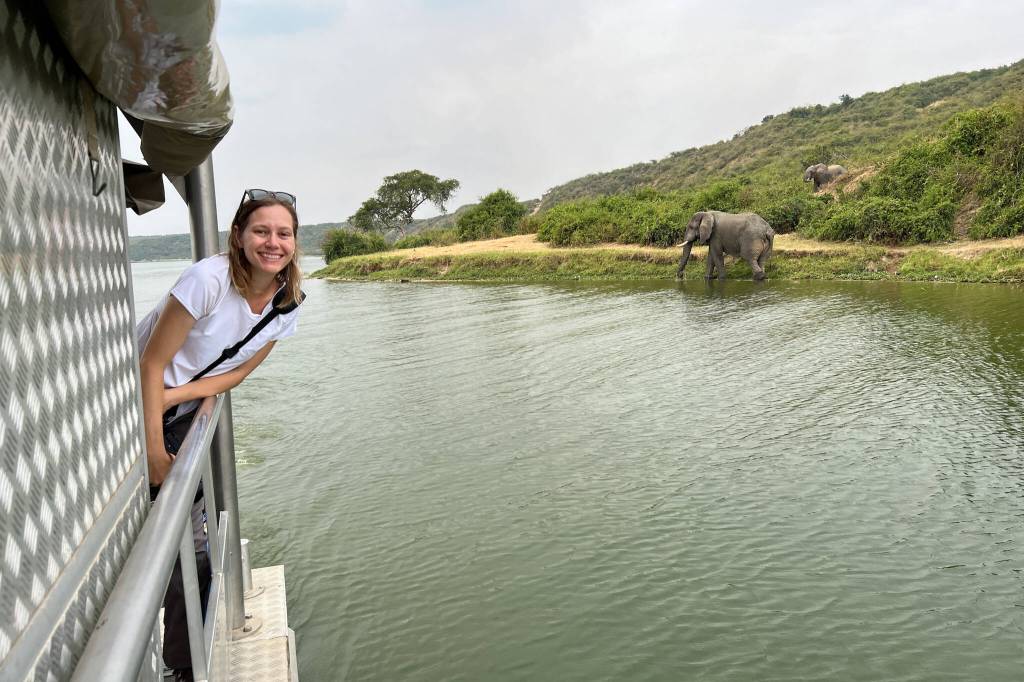 Kim Tate, author of the travel blog Stuffed Suitcase, poses next to an elephant in Uganda. (Photo courtesy of Kim Tate)