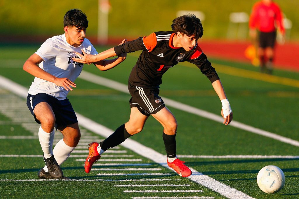 Monroes Tony Granados slips past Everetts Roberto Mata Castellon during a 3A District soccer match on Thursday, May 2, 2024, at Monroe High School in Monroe, Washington. (Ryan Berry / The Herald)